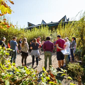 Adults standing outside in a circle doing training at the Eden Project